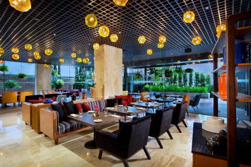 un restaurante con mesas, sillas y luces en DoubleTree by Hilton Sukhumvit Bangkok en Bangkok