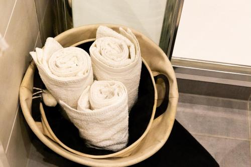 un panier rempli de serviettes blanches sur un mur dans l'établissement Appartement entier Strasbourg Centre, à Strasbourg