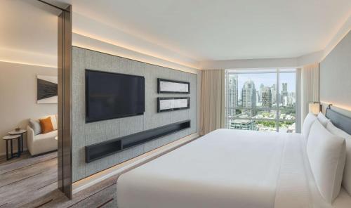 a hotel room with a large bed and a flat screen tv at DoubleTree by Hilton Bangkok Ploenchit in Bangkok
