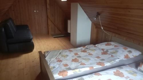 1 dormitorio pequeño con 1 cama y 1 silla en Srub Rtyně, en Rtyně v Podkrkonoší