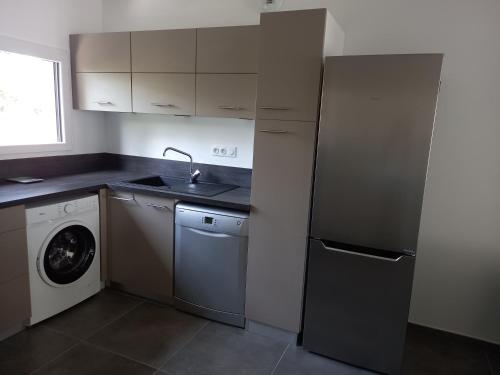 Il comprend une cuisine équipée d'un réfrigérateur et d'un lave-linge/sèche-linge. dans l'établissement Lodge coeur nature T3, à Argelès-sur-Mer