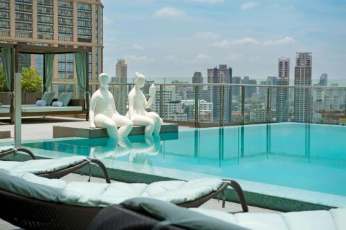 uma piscina no último piso com vista para a cidade em Hilton Sukhumvit Bangkok em Bangkok