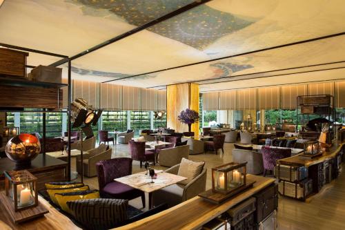 un restaurante con mesas y sillas en una habitación en Hilton Sukhumvit Bangkok, en Bangkok