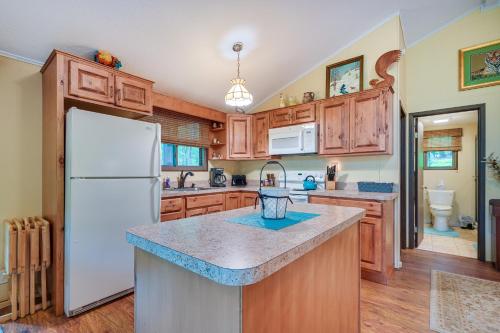 a kitchen with wooden cabinets and a white refrigerator at Charming Hedgesville Retreat with Deck and Fireplace! in Hedgesville
