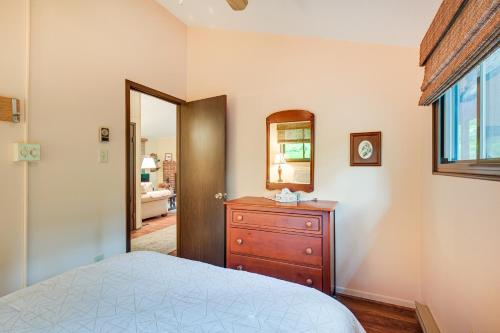 a bedroom with a bed and a dresser and a mirror at Charming Hedgesville Retreat with Deck and Fireplace! in Hedgesville