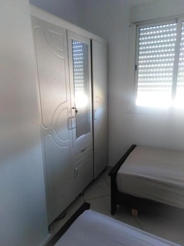 a room with a door and a bed and a window at Appartement sur la route de la plage de Achakar in Tangier