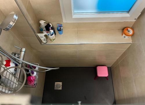 mit Blick auf ein Bad mit einem rosa Stuhl in der Unterkunft Habitación con baño compartido in Madrid