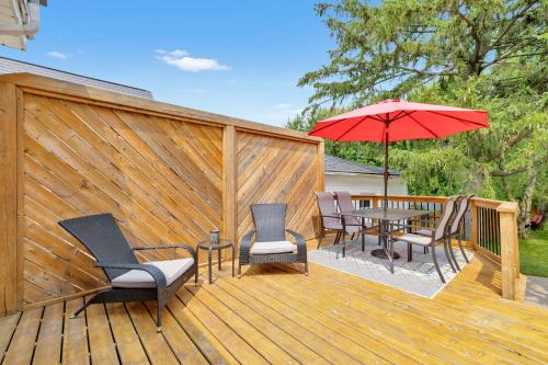 a wooden deck with chairs and a table with an umbrella at Cozy Kingsville Country Home Guest House in Kingsville