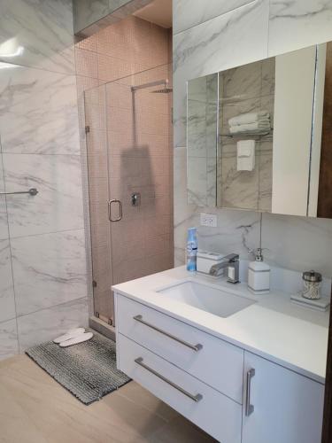 a bathroom with a white sink and a shower at Luxury Beachfront Condo in Rosarito with Pool & Jacuzzi in Rosarito