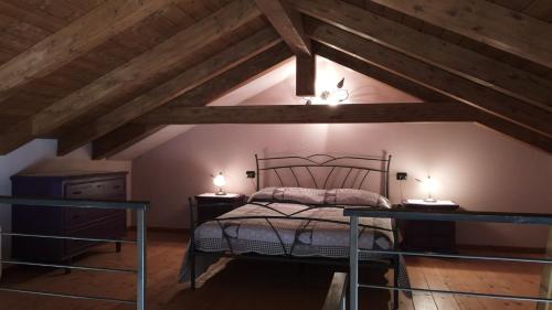 a attic bedroom with a bed and two tables at LA CASA IN CAMPAGNA esclusiva in Calosso