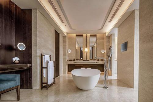 a bathroom with a large tub and a sink at Waldorf Astoria Bangkok in Bangkok