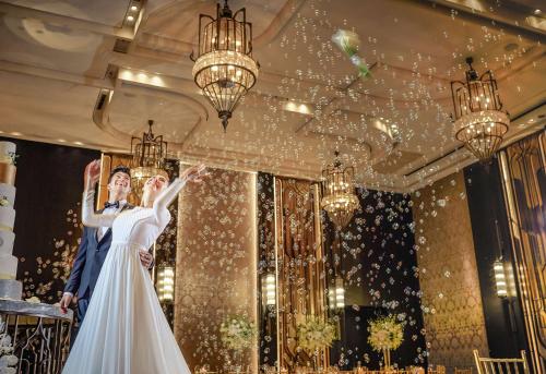 a bride and groom jumping in the air at their wedding at Waldorf Astoria Bangkok in Bangkok