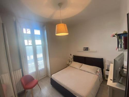 1 dormitorio con 1 cama y 1 silla roja en Casa Sobborghi en Monza
