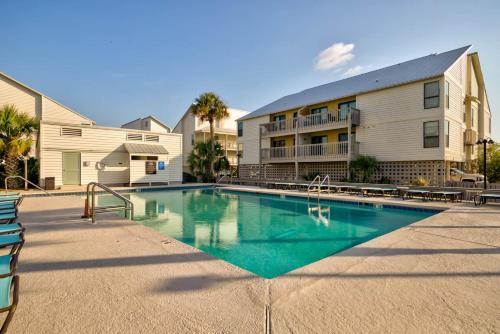 a swimming pool in front of a building at Cotton Bayou 7H by Vacation Homes Collection in Orange Beach