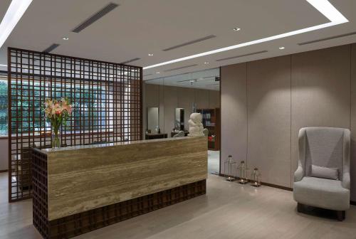 a lobby with a reception desk and a chair at Hilton Bangalore Embassy GolfLinks in Bengaluru