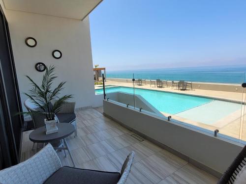 ein Hotelzimmer mit einem Pool, einem Tisch und Stühlen in der Unterkunft Seafront Luxury Condo in Rosarito with Pool & Jacuzzi in Rosarito
