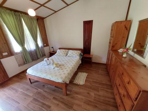 a bedroom with a bed and a wooden floor at Casa Mairena in Caño Negro