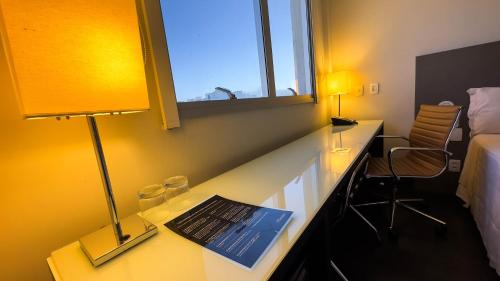 a hotel room with a desk with a laptop on it at Hotel Gran Vivenzo Belo Horizonte in Belo Horizonte