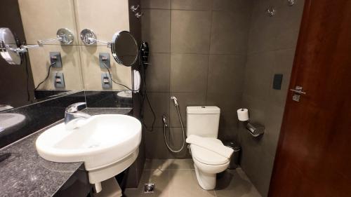 a bathroom with a white toilet and a sink at Hotel Gran Vivenzo Belo Horizonte in Belo Horizonte