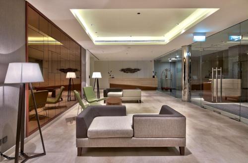 a lobby with a couch and chairs and a table at Hilton Colombo Residence in Colombo