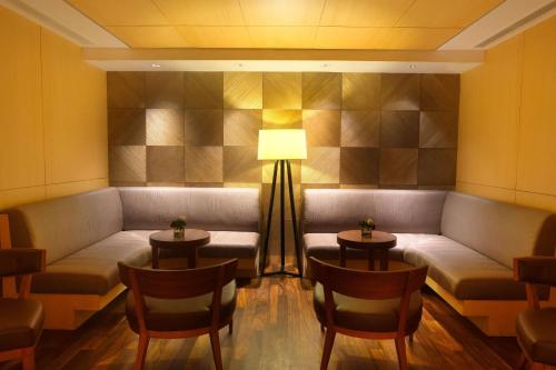 a waiting room with a couch and chairs and a lamp at Hilton Colombo Residence in Colombo