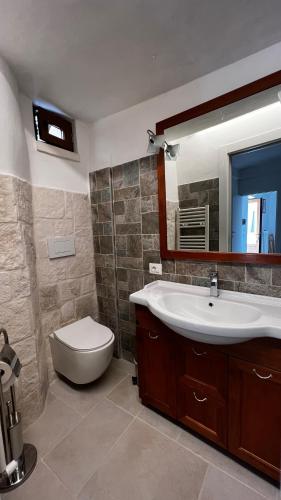 a bathroom with a sink and a toilet and a mirror at Locazione turistica il boschetto in Martina Franca