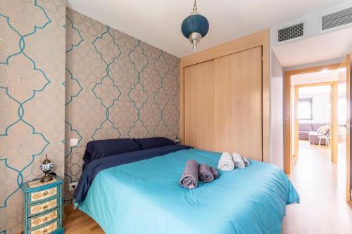 een slaapkamer met een blauw bed met 2 handdoeken erop bij Home Sweet Home in Madrid
