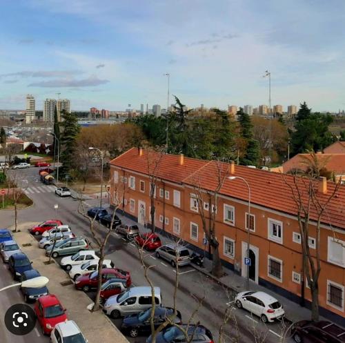 un estacionamiento con autos estacionados frente a un edificio en HABITACIÓN PRIVADA EN PISO a 10 minutos de Atocha, en Madrid