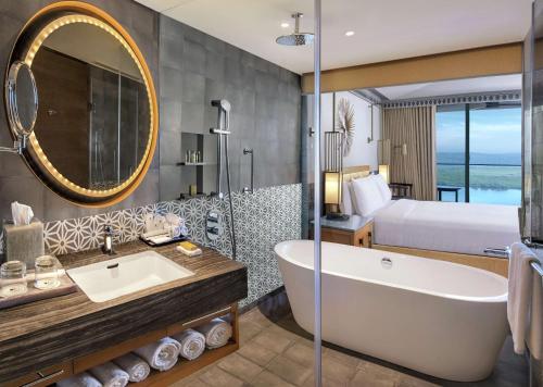 帕納吉的住宿－DoubleTree by Hilton Goa - Panaji，带浴缸的浴室和1间带1张床的卧室