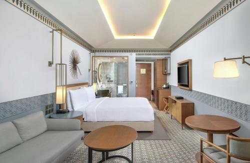 a hotel room with a bed and a living room at DoubleTree by Hilton Goa - Panaji in Panaji
