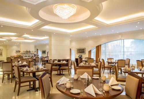 a restaurant with tables and chairs and a chandelier at Hilton Garden Inn Hanoi in Hanoi