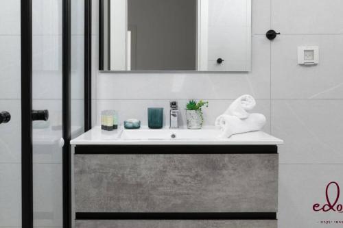 a bathroom with a sink with a statue on it at דירה משפחתית במתחם סי סייד - By Edomlux in Eilat