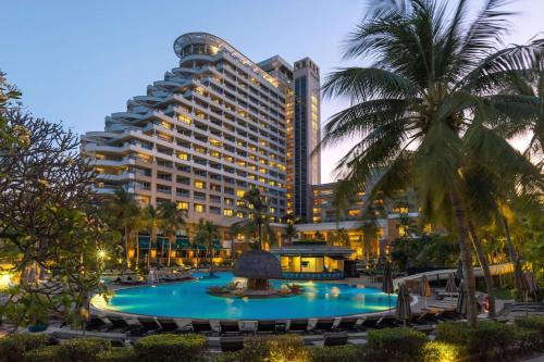 un hotel con una gran piscina frente a un edificio en Hilton Hua Hin Resort & Spa en Hua Hin