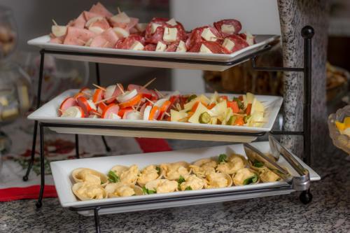 two trays filled with different types of food on plates at Hotel Penha in Penha
