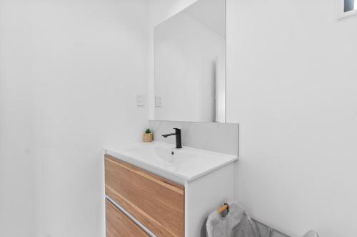 a bathroom with a white sink and a mirror at New 3bds house walk to Rototuna shopping Centre in Hamilton