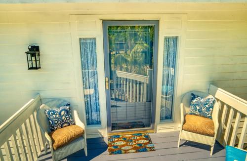 a porch with two chairs and a glass door at Henderson home in Sanibel