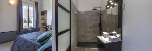 a bathroom with a bed and a shower in a room at Chambre d'Hôtes Les Jardins de Marie, SCI Charles III in Bernay