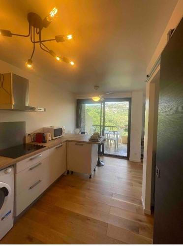 une cuisine avec un comptoir et une table à l'intérieur dans l'établissement Porticcio avec Piscine proche plage, à Porticcio