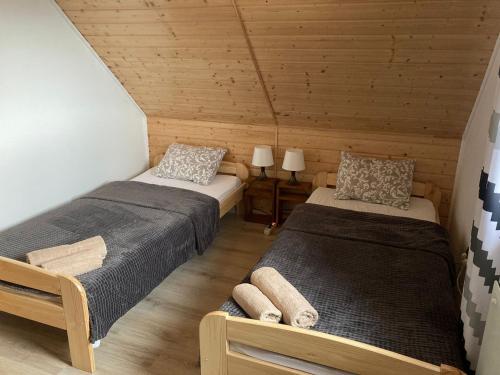 sypialnia z 2 łóżkami w drewnianym domku w obiekcie Domek Pod Skałkami w mieście Idzików
