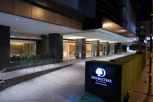 新山的住宿－DoubleTree by Hilton Johor Bahru，一座建筑,在晚上前有标志