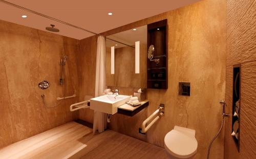 a bathroom with a sink and a shower and a toilet at Hilton Jaipur in Jaipur