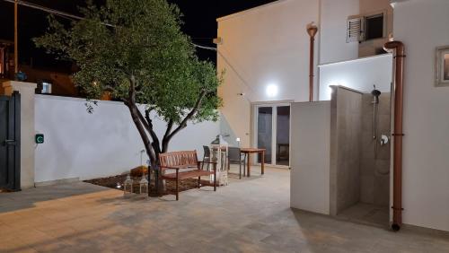 a house with a tree in the middle of a courtyard at Uccio e Gina in Soleto