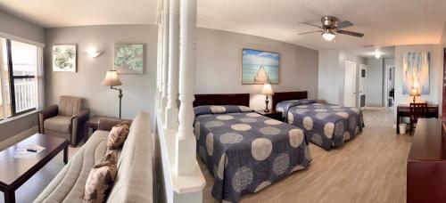 a bedroom with two beds and a living room at Sails Resort Motel in St. Pete Beach