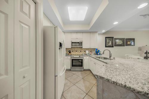 a kitchen with white cabinets and a white refrigerator at San Carlos 1604 by Vacation Homes Collection in Gulf Shores