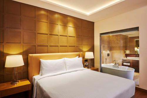 a bedroom with a bed and a tub in a room at Hilton Garden Inn Lucknow in Lucknow