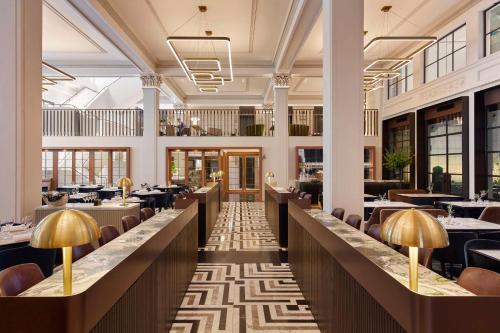 a view of a restaurant with tables and chairs at Hilton Melbourne Little Queen Street in Melbourne