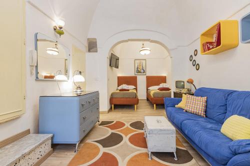 een woonkamer met een blauwe bank en een slaapkamer bij House with Amazing Sea View in Polignano a Mare