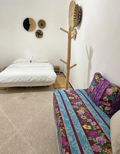 a bedroom with a bed and a fan on the wall at Kasbari House in Taghazout