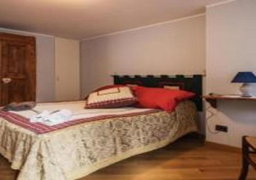 Un dormitorio con una cama con almohadas rojas. en La Ca d'Piazi en Viù