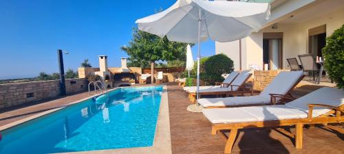 a swimming pool with lounge chairs and an umbrella at Villa Callisto in Loutra
